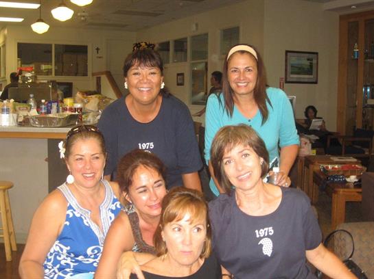 A joyful gathering of friends dressed casually in matching shirts, smiling and interacting.