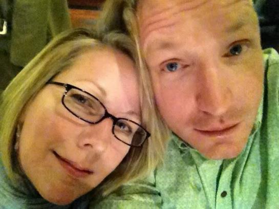 Two friends posing closely together, smiling and sharing a lighthearted moment at dinner.