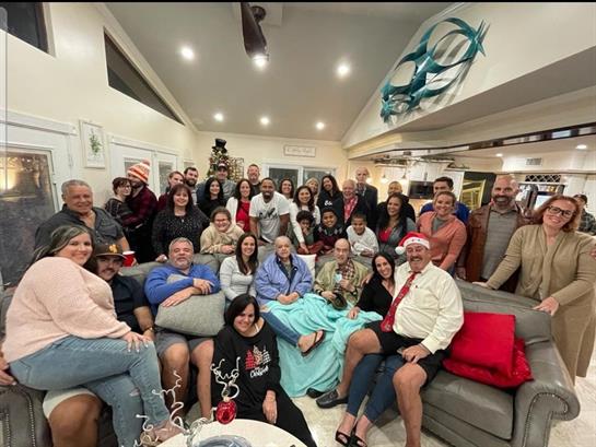 Friends and family celebrate together in a cozy indoor space during the winter holiday season.