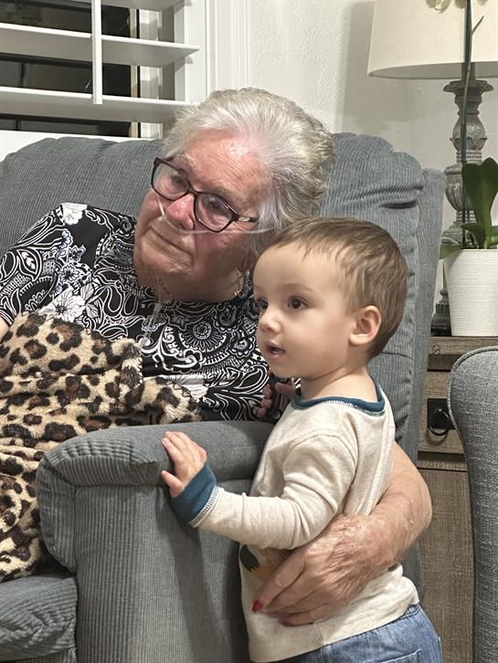 A grandmother and her grandson relax together in the living room on a peaceful evening.