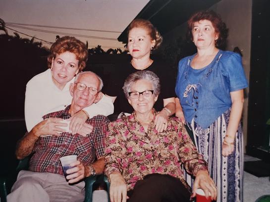 Five relatives enjoy each other's company, sharing laughter and memories at a festive event.