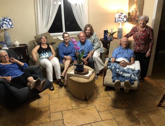 Friends and family enjoy quality time together in a comfortable living space with warm lights.