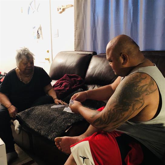 Elderly woman and man enjoy a card game together in a cozy living room environment.