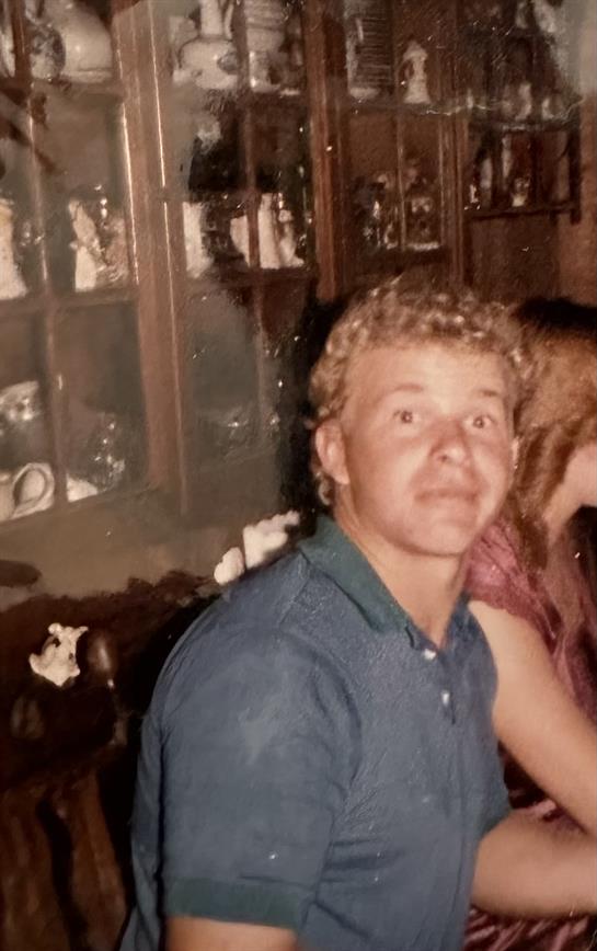 Two young people share a moment at a friendly gathering surrounded by sentimental decor.