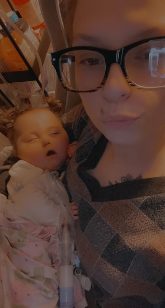 Mother lovingly cradles her sleeping infant, showcasing a warm bond in a living room.