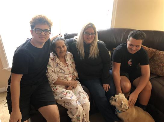 Four family members enjoy quality time in a cozy living room, fostering connection and love.