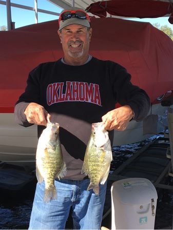 A man holding two fish