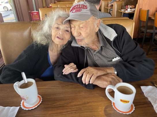 A man and woman sitting at a table with coffee cups