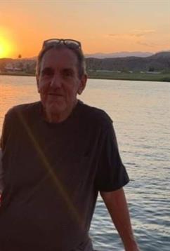 A person stands by the water, appreciating the tranquil sunset and serene surroundings.