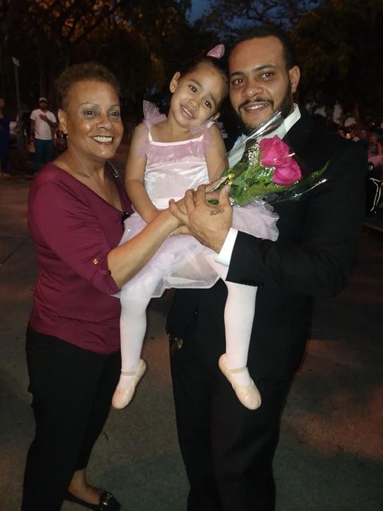 A joyful family enjoys a special moment during an evening gathering with a young girl.