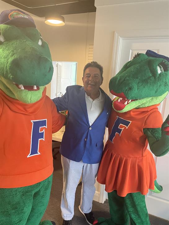 A man standing next to two mascots