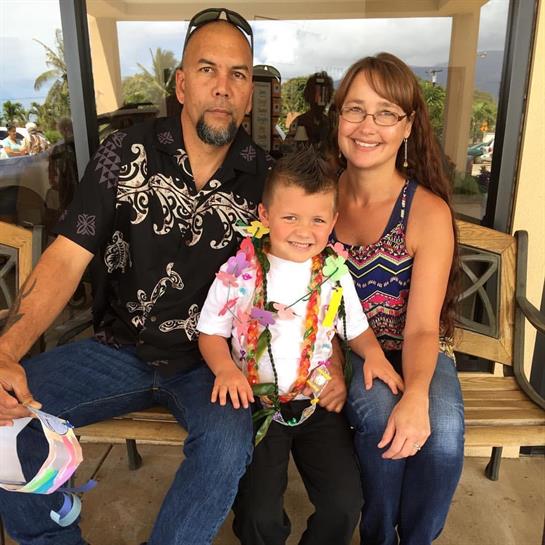 Family enjoys quality time sitting on a bench in a warm, tropical location with smiles and laughter.