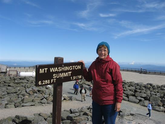 A woman standing next to a sign