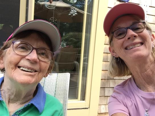 Two women wearing hats and smiling
