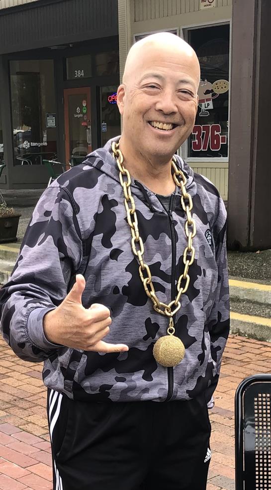 Individual in camouflage attire makes a friendly gesture outdoors, showcasing a unique style.