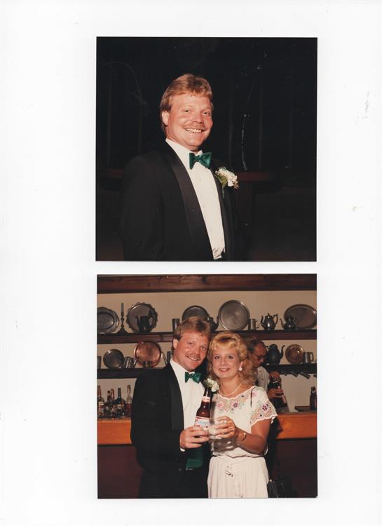 A man and woman enjoy each other's company while celebrating at a formal event, dressed elegantly.