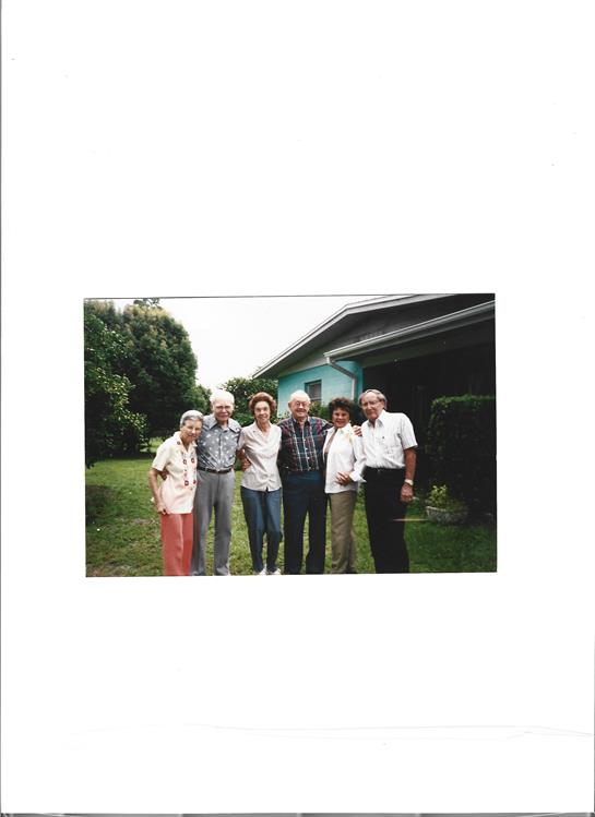 Friends enjoying a joyful moment together in a garden setting, with greenery all around.