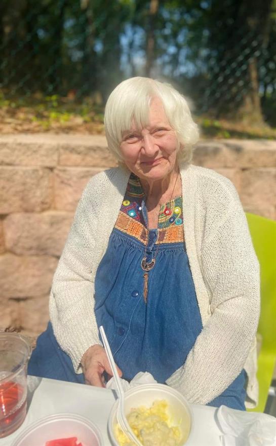 A woman sitting outside holding a pen