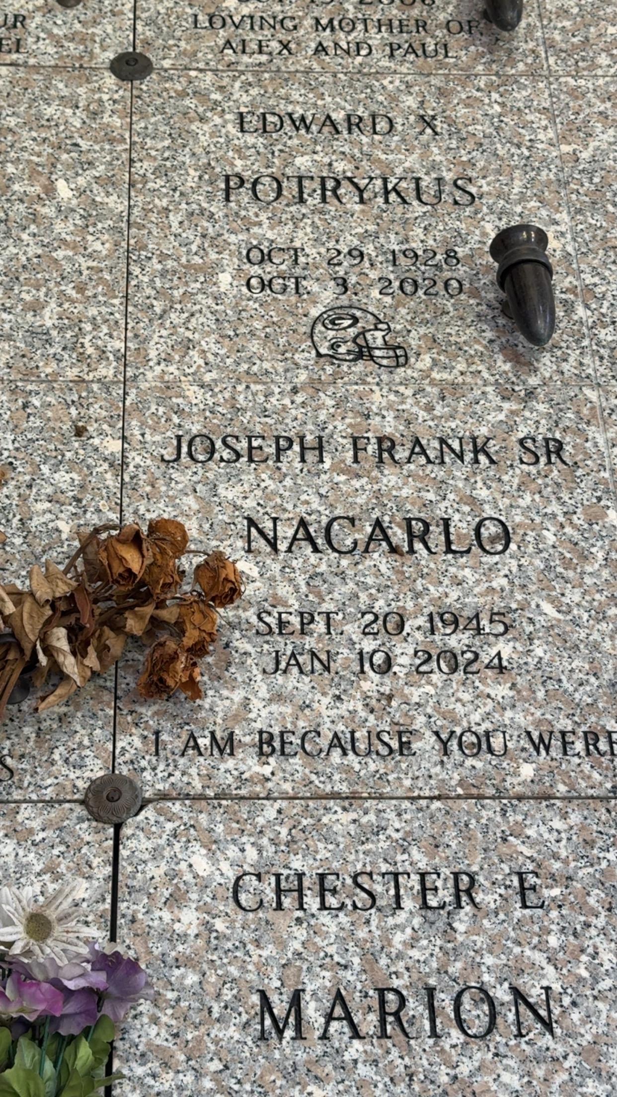 A grave stone with a bullet and flowers
