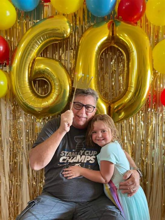 Happiness fills the air as a family enjoys a milestone birthday celebration surrounded by balloons.