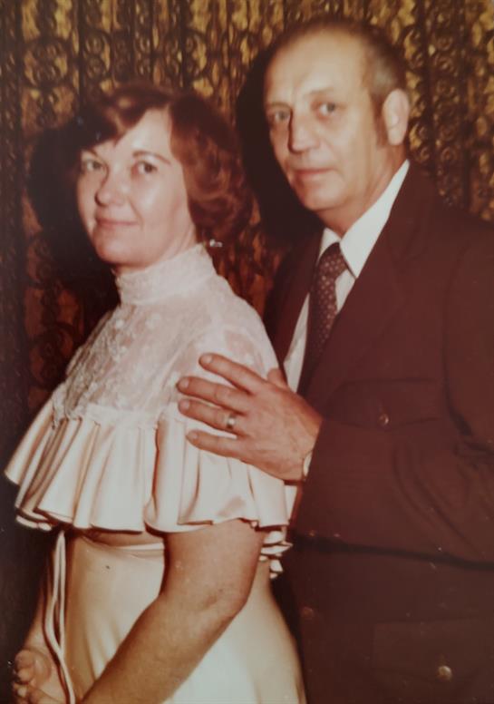 Couple dressed elegantly, showcasing a close bond and warm expressions in their attire.