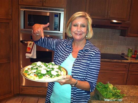 A woman holding a pizza