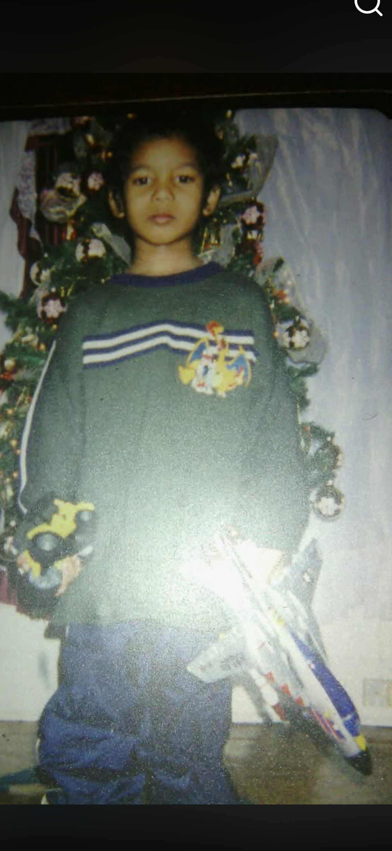 A boy standing in front of a christmas tree