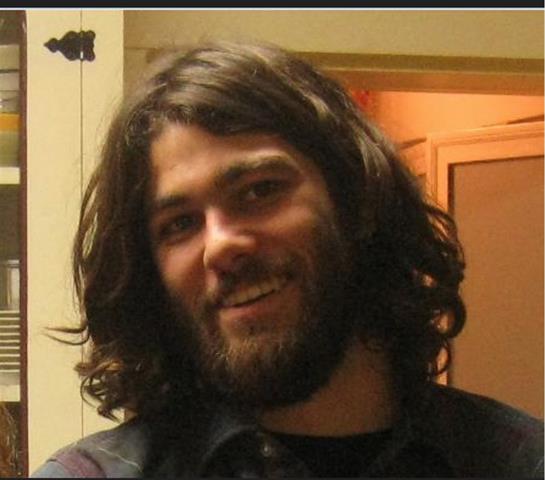 A man with long hair and beard smiling