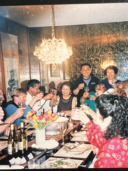 A festive group toasts together at a lively dinner party filled with laughter and joy.