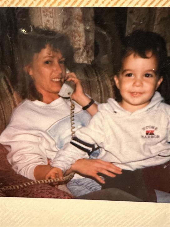 A woman holding a phone to her child