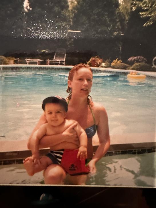 A woman holding a baby in a pool