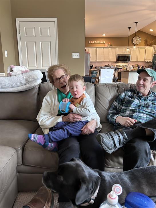 A man and woman sitting on a couch with a baby