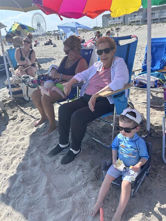 A group of people sitting in chairs at a beach