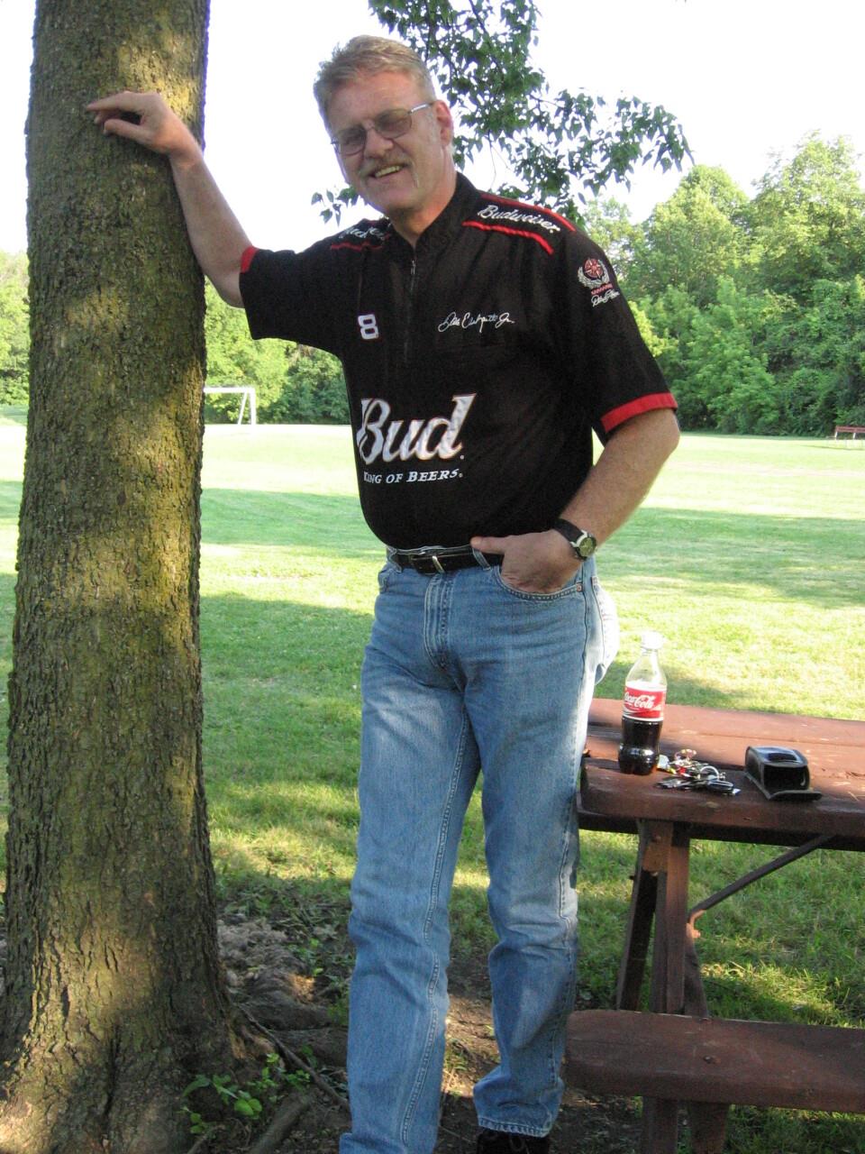 A man standing next to a tree