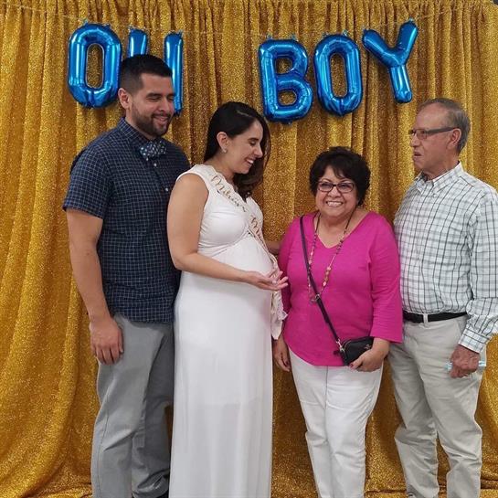 Family members gather to celebrate an expecting couple at a baby shower, sharing smiles and joy.