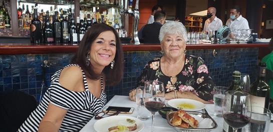 Two women sitting at a table with food