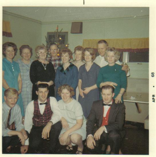 Friends gather for a joyful moment in a retro room, showcasing their outfits from the 1960s.