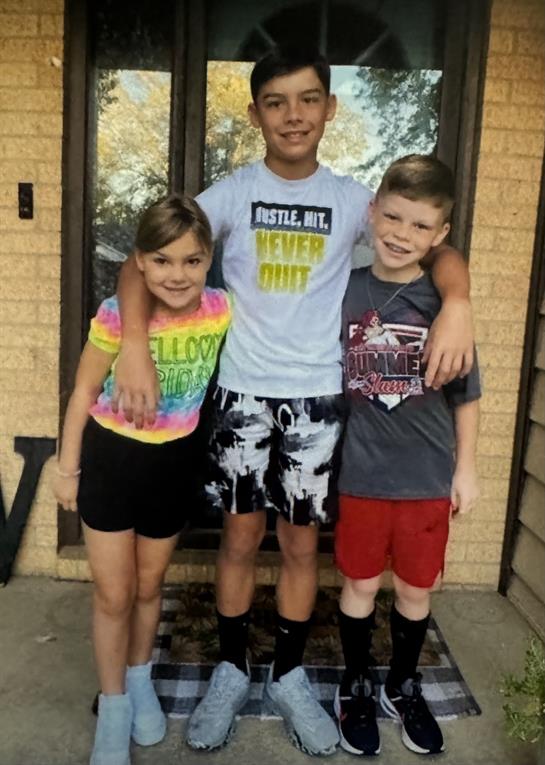 A group of kids standing together in front of a door