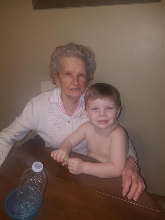 An older woman and a young boy sitting at a table