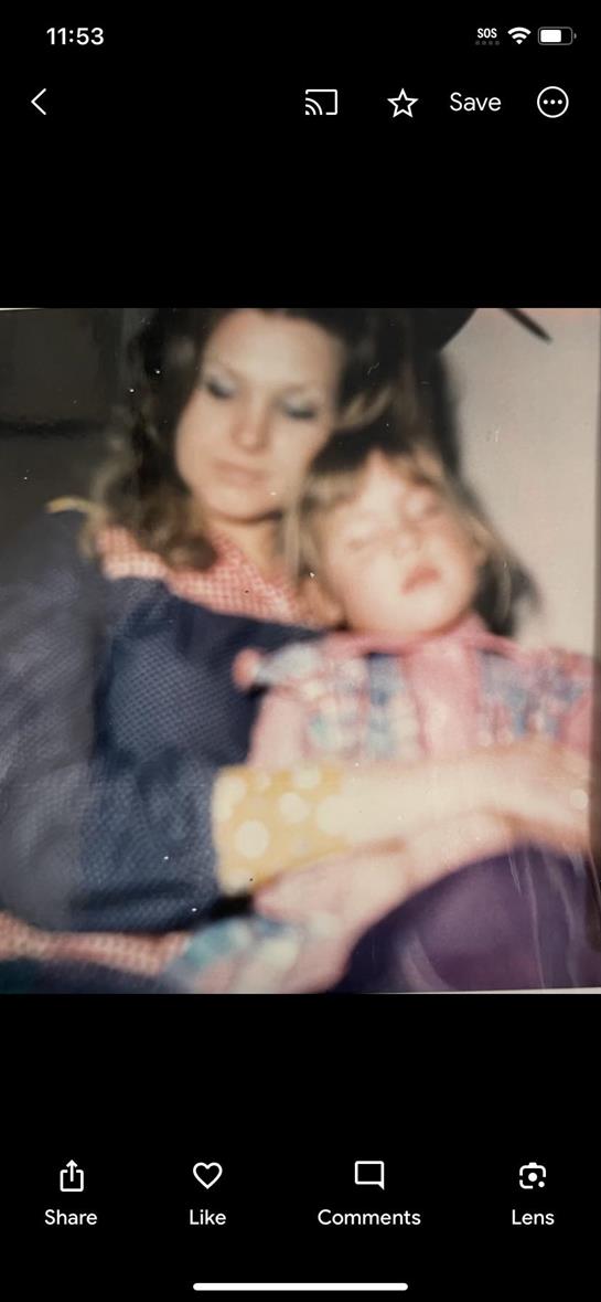 A mother lovingly cradles her dozing child in a warm, intimate home environment.