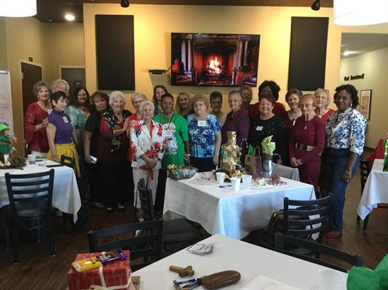 A lively gathering of women enjoying food and conversation in a cozy restaurant setting.