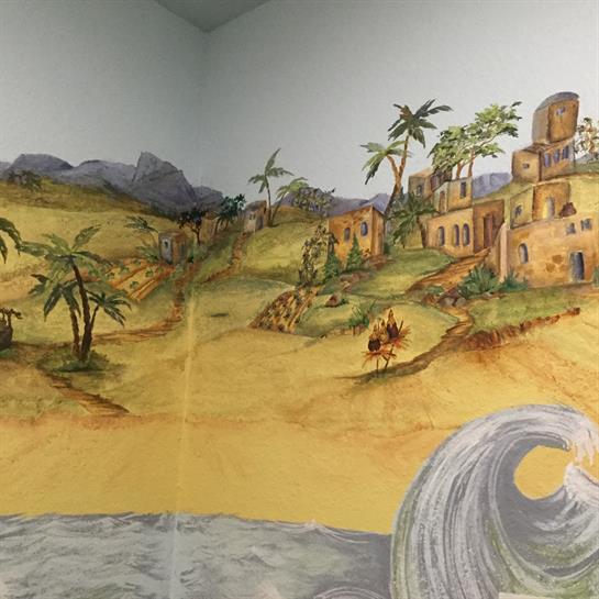 A vibrant mural captures a coastal landscape with palm trees and weathered ruins under a sunny sky.