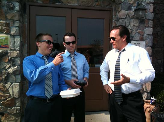 A group of men in formal attire outside a building