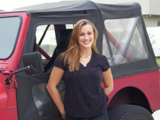 A woman standing in front of a car