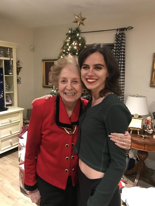 A joyful gathering featuring two women smiling while posing in a festively decorated room.