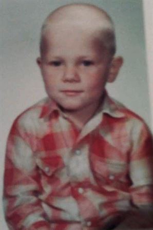 A boy in a red and white plaid shirt