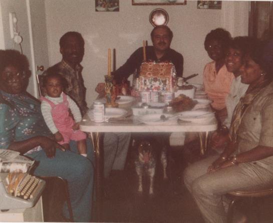 Family and friends enjoy dinner together while celebrating a special occasion.