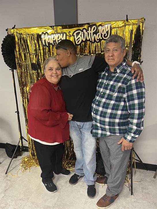 Family celebrating a birthday together, enjoying the moment with smiles in a decorated room.