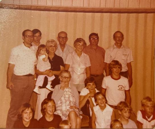 A large family poses together, showcasing a mix of ages and relationships, celebrating togetherness.