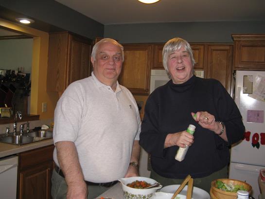 Friends are happily cooking together in a warm kitchen, sharing laughs and conversation.
